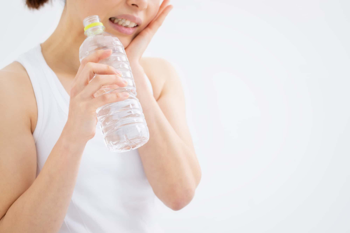 虫歯の初期症状で冷たい飲み物が歯にしみる女性
