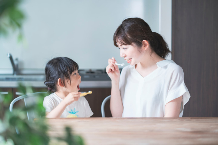 虫歯を予防するために歯磨きする親子