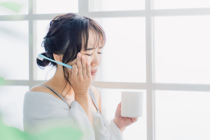 虫歯を放置して歯がしみる女性