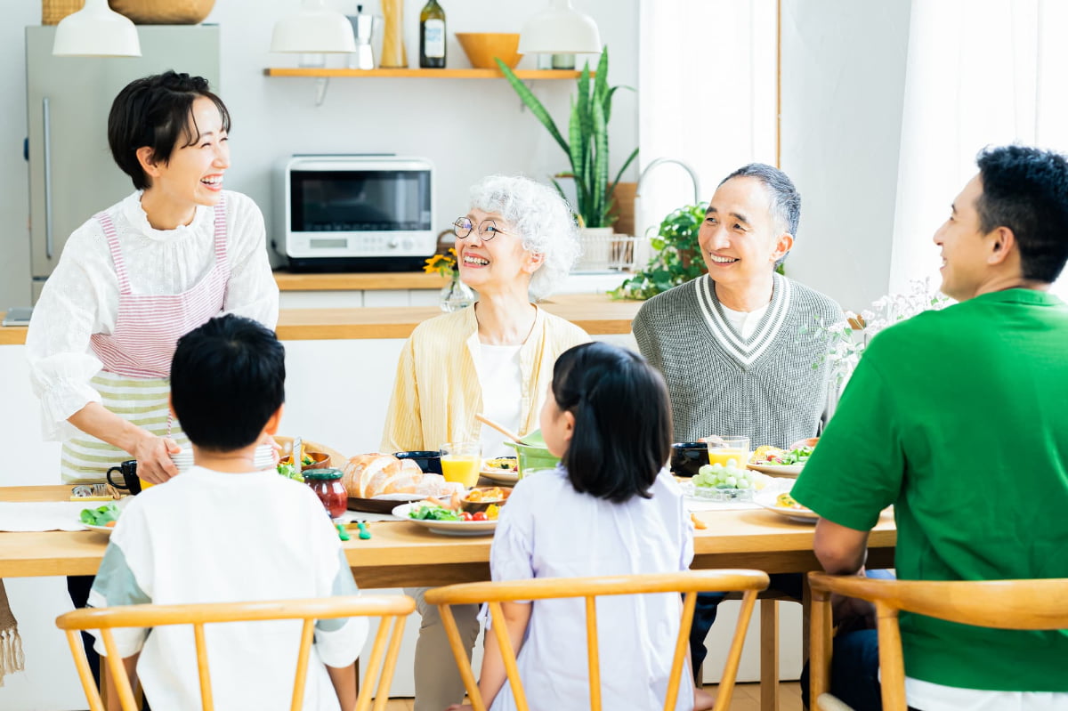 インプラント周囲炎の治療をしたシニア夫婦が家族と食事を楽しんでいる様子