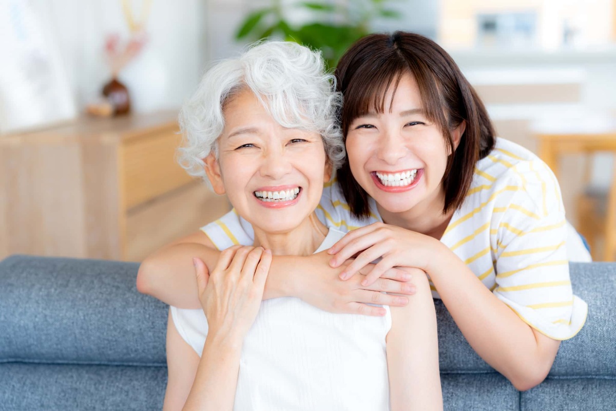 インプラント治療を無事にやり直して孫と喜びあっているシニア女性